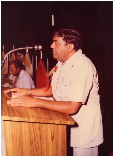 The late Shri Moolchand Agarwal speaking at a lectern